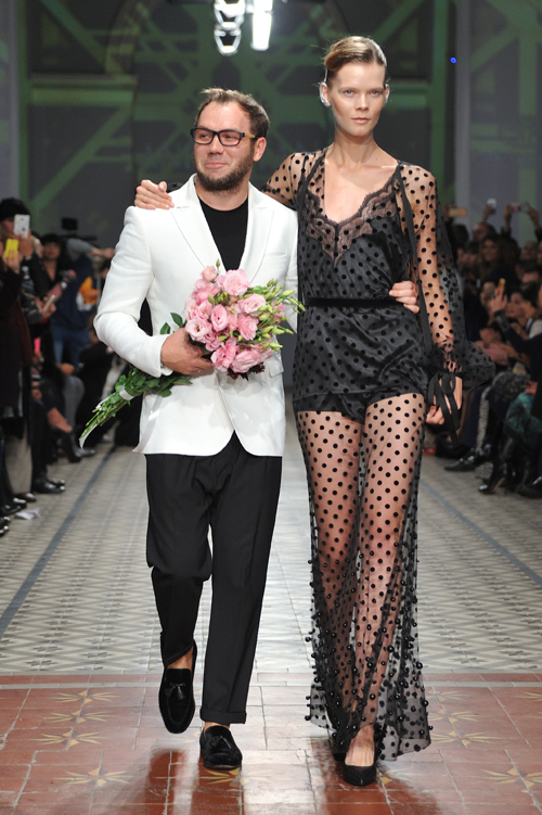 Andre Tan y Irina Kravchenko. Desfile de Andre Tan — Ukrainian Fashion Week SS17 (looks: gafas, , camiseta negra, , pantalón negro, vestido de noche de lunares negro transparente)